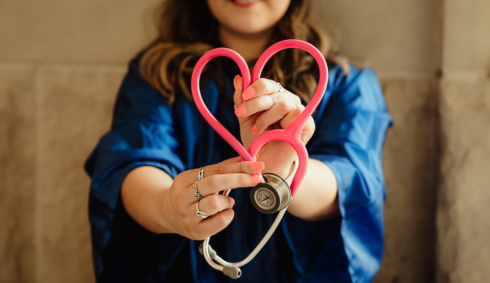 Nurse holding stethoscope in the shape of a heart